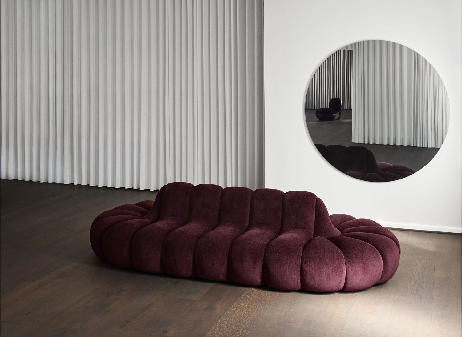 Jagger Lounge Sofa in a burgundy Athena fabric in front of a mirror.