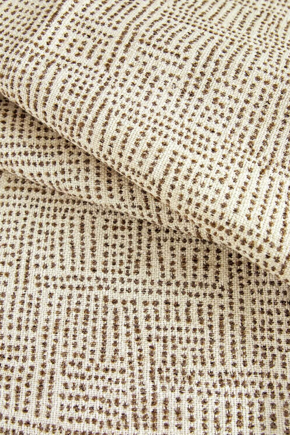 Close-up of textured beige fabric with a subtle pattern