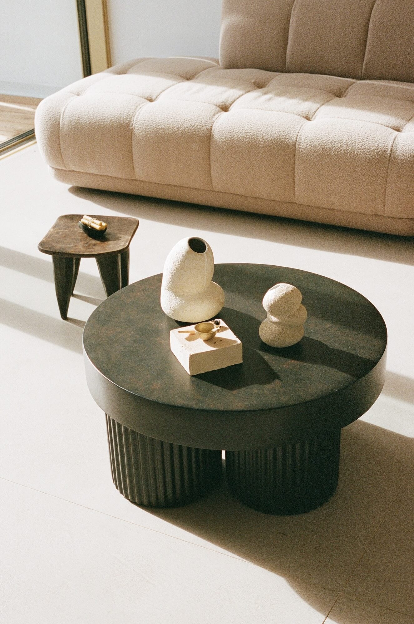 Round coffee table with decorative items in a living room setting